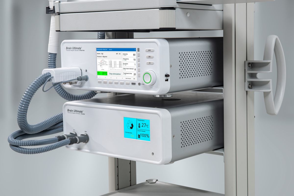 The BrainUltimate M-Series stimulator and cooling unit, with treatment settings shown on the front display.